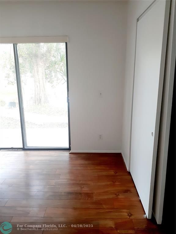 Undisclosed Address Coral Springs, FL 33065 - Photo 11 of 13 an empty room with wooden floor and windows