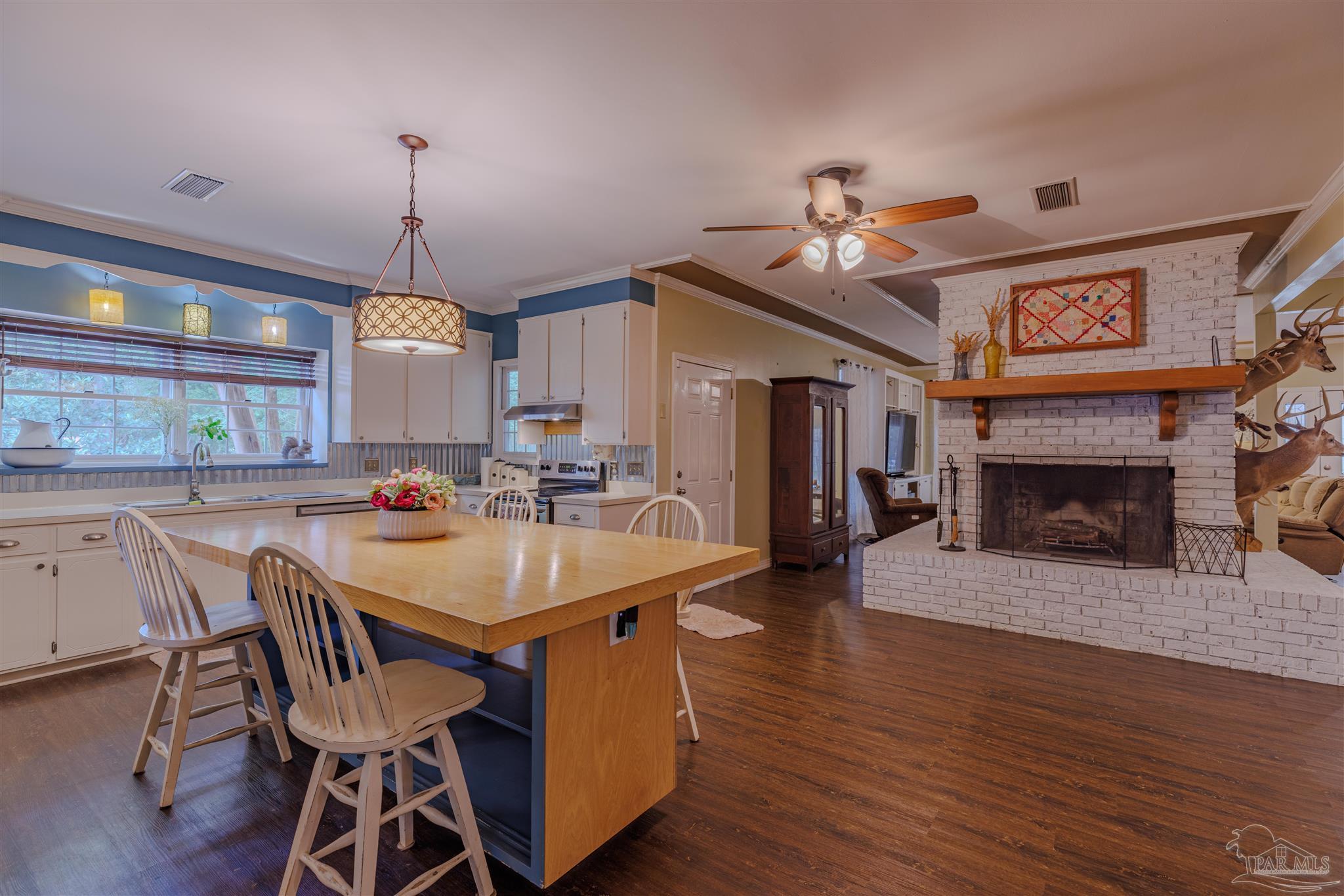 5049 Guernsey Road Pace, FL 32571 - Photo 27 of 61 a dining room with furniture a fireplace and wooden floor