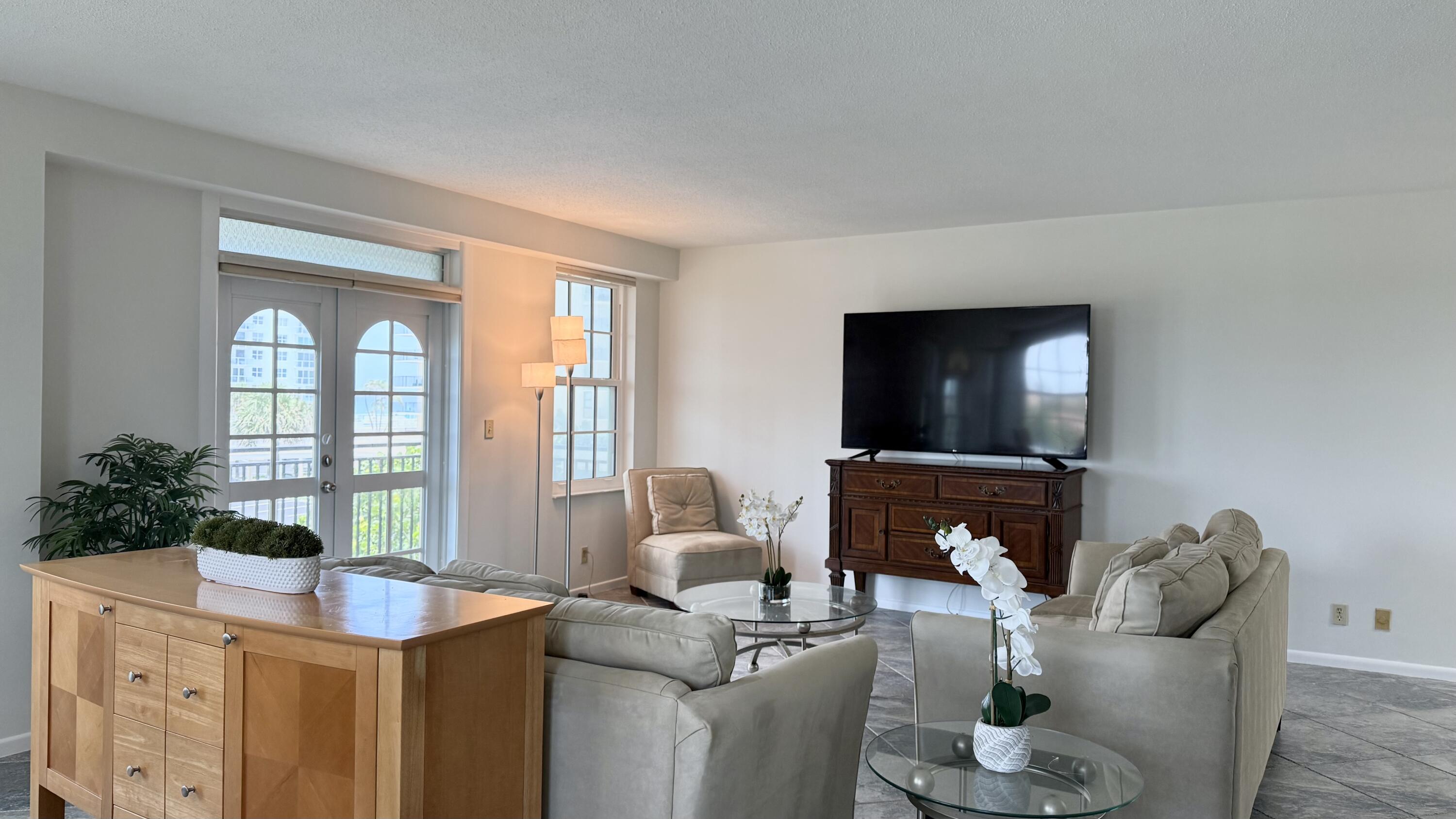 3475 South Ocean Boulevard, Unit 2160 Palm Beach, FL 33480 - Photo 11 of 54 a living room with furniture and a flat screen tv