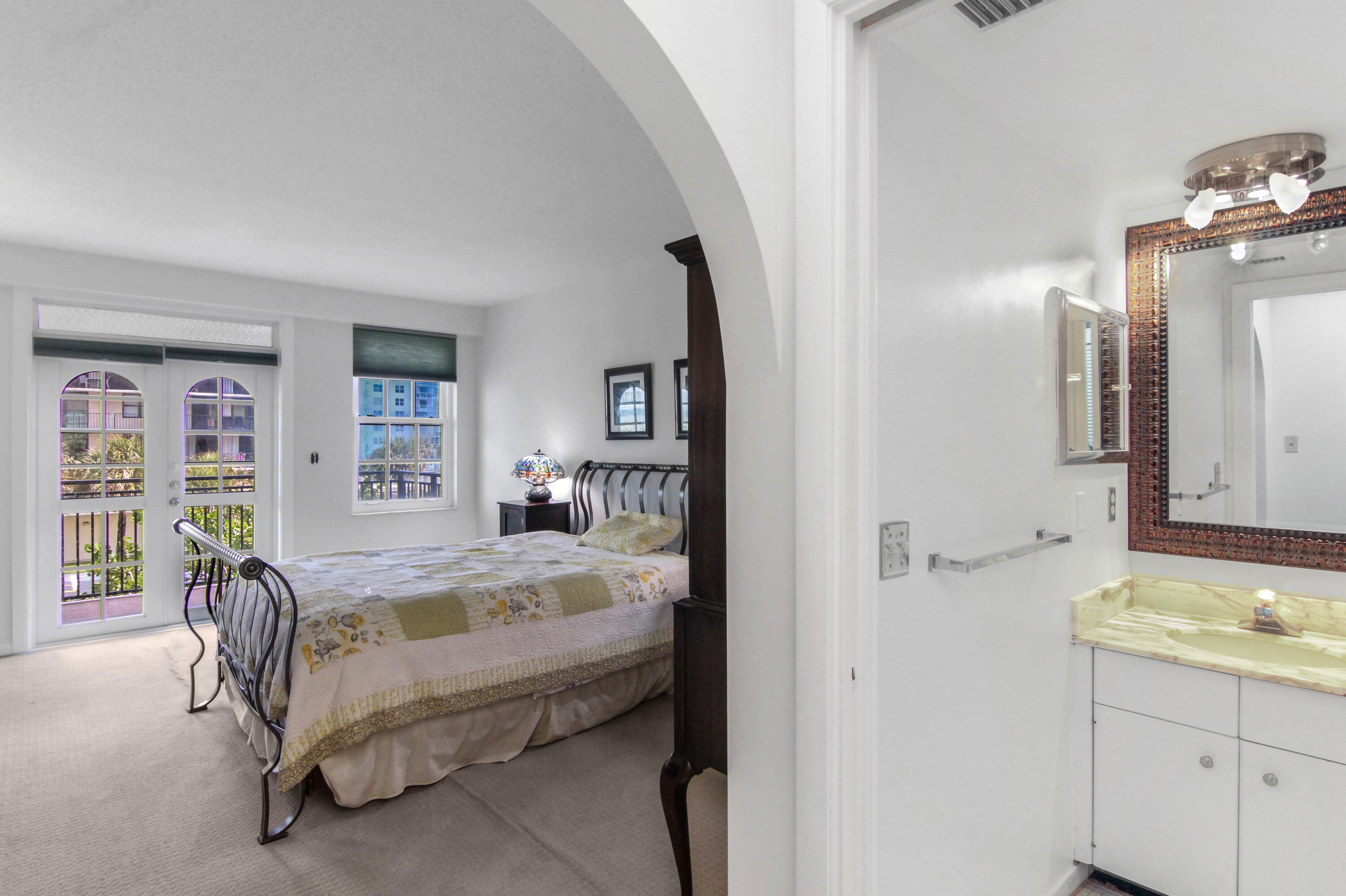 3475 South Ocean Boulevard, Unit 2160 Palm Beach, FL 33480 - Photo 25 of 54 a bedroom with a bed a mirror and a window