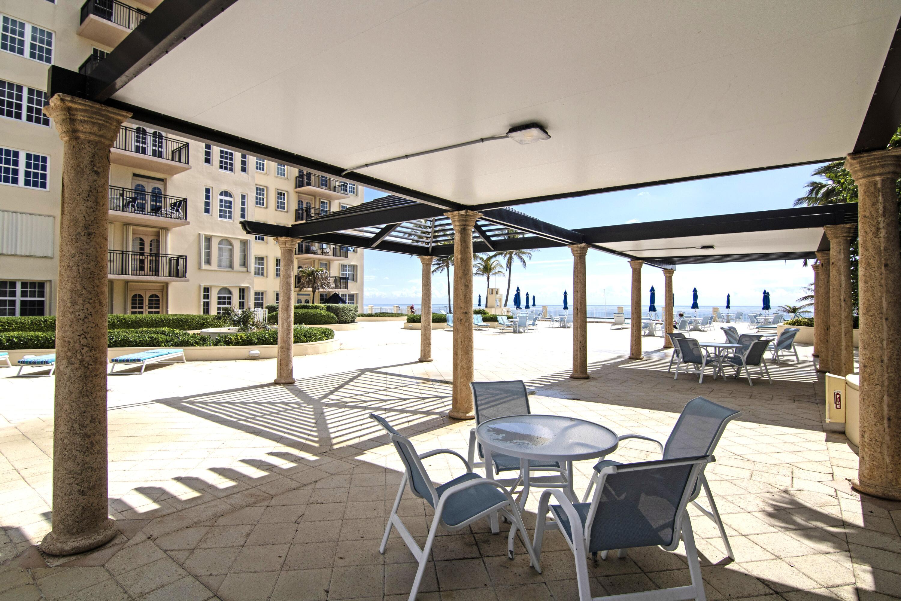 3475 South Ocean Boulevard, Unit 2160 Palm Beach, FL 33480 - Photo 46 of 54 a view of a patio with table and chairs and potted plants