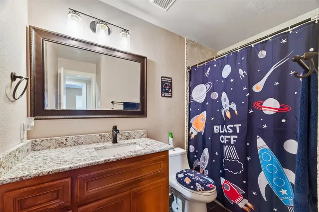 a bathroom with a granite countertop sink and a mirror