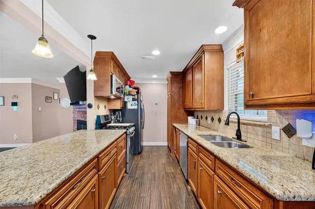 a kitchen with stainless steel appliances granite countertop a sink and a refrigerator