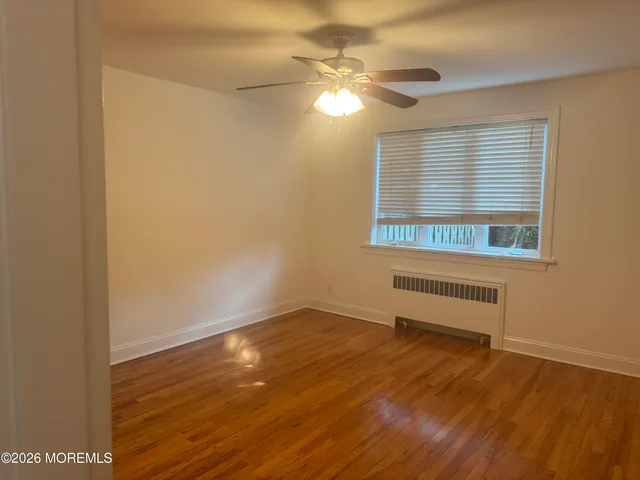 a view of a room with wooden floor and fan