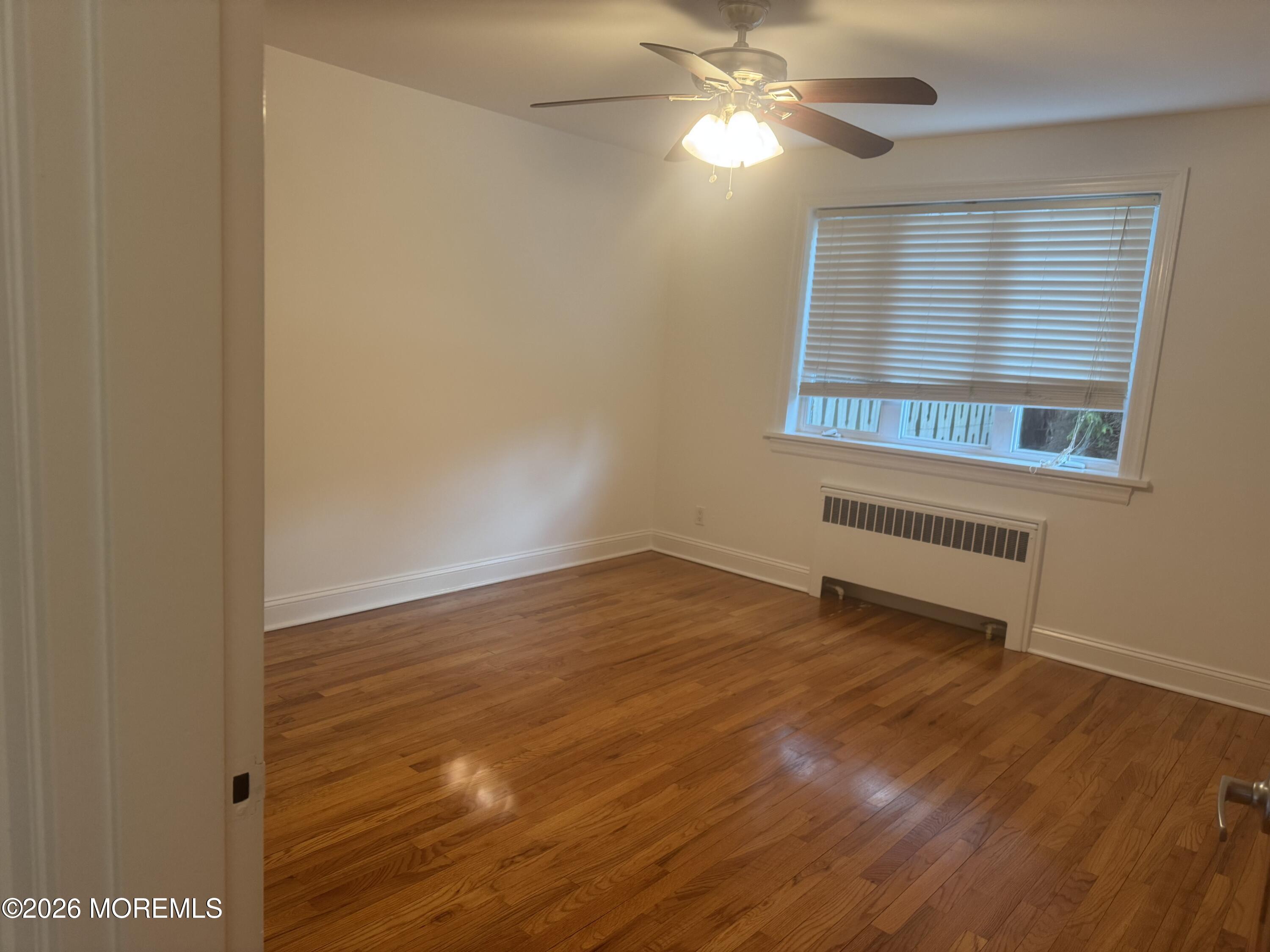 283 Spring Street, Unit 5B Red Bank, NJ 07701 - Photo 16 of 18 an empty room with wooden floor and windows