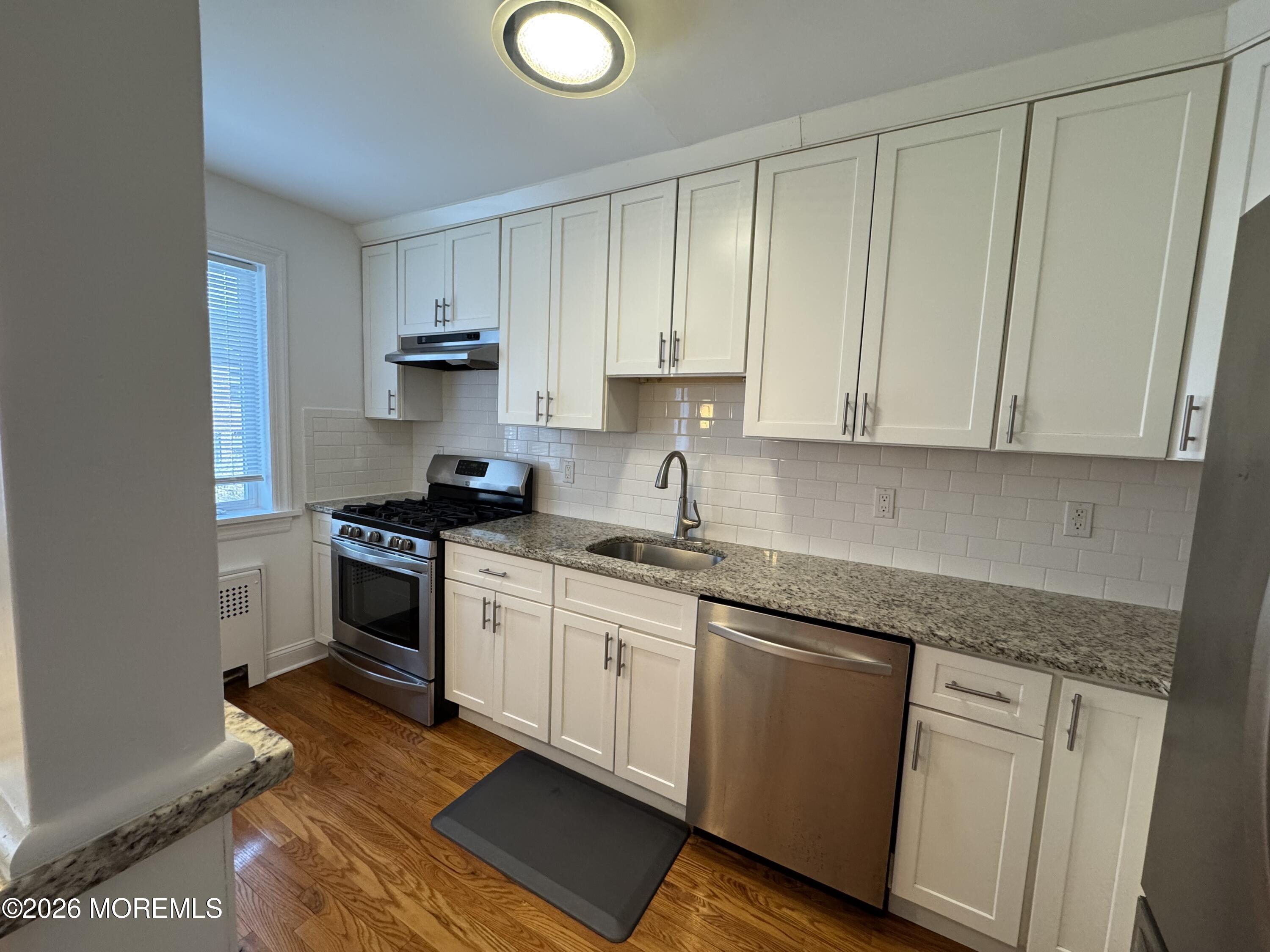 283 Spring Street, Unit 5B Red Bank, NJ 07701 - Photo 5 of 18 a kitchen with granite countertop white cabinets and stainless steel appliances
