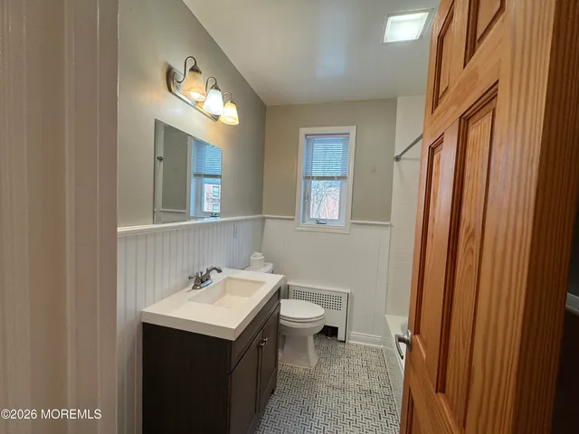 a bathroom with a sink a toilet and a mirror