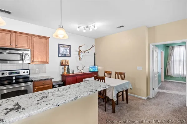 a kitchen with sink refrigerator dining table and chairs