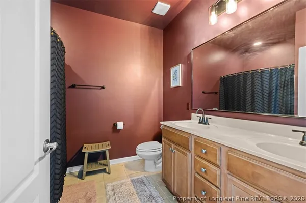 a spacious bathroom with a granite countertop sink a toilet and a mirror