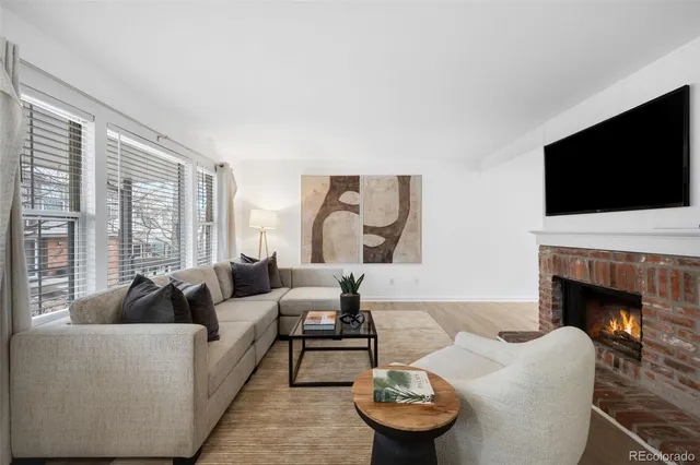 a living room with furniture a fireplace and a flat screen tv