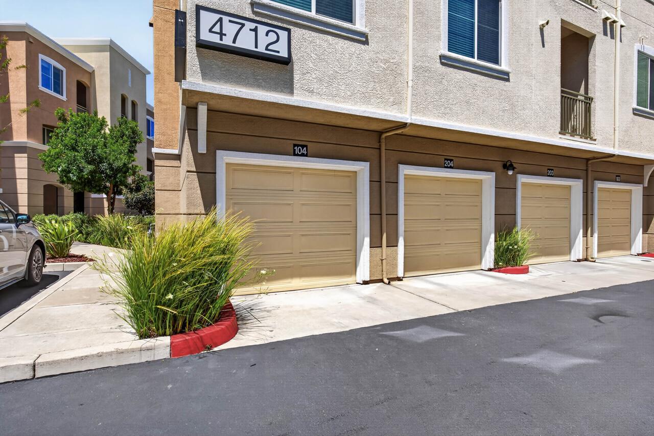 4712 Norris Canyon Road, Unit 104 San Ramon, CA 94583 - Photo 18 of 22 a front view of a house with a yard and garage