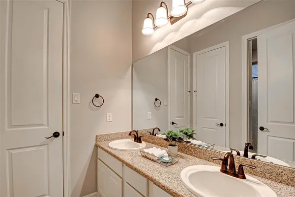 a bathroom with double vanity sinks and a mirror