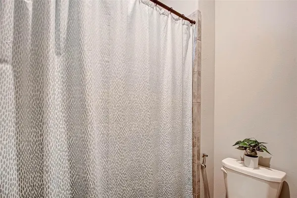 a bathroom with a shower curtain and a toilet