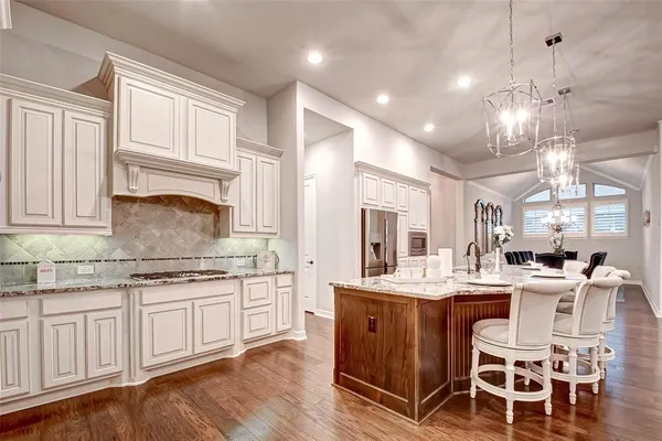 a kitchen with cabinets a sink dining table and chairs