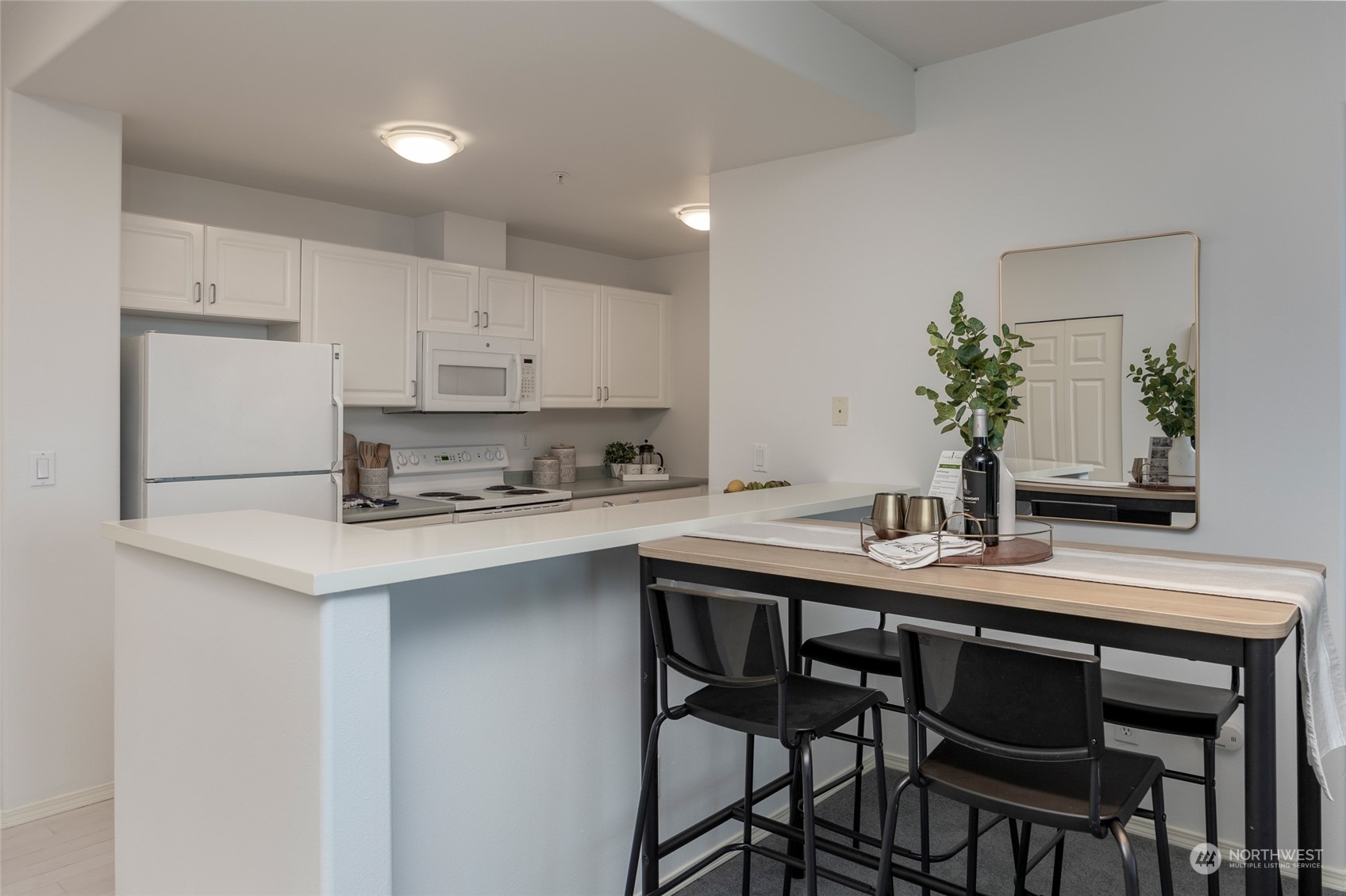 3221 Southwest Avalon Way, Unit 305 Seattle, WA 98126 - Photo 14 of 40 a kitchen with a table chairs sink and cabinets
