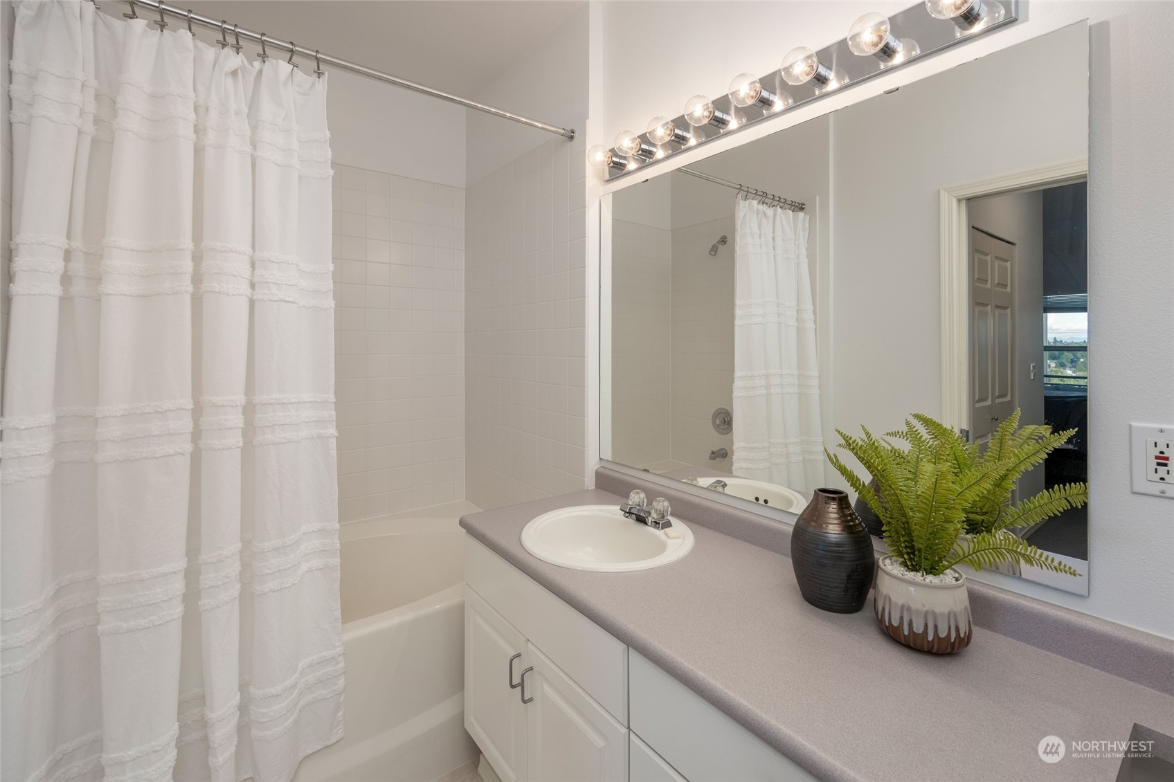 3221 Southwest Avalon Way, Unit 305 Seattle, WA 98126 - Photo 20 of 40 a bathroom with a sink a mirror and a potted plant