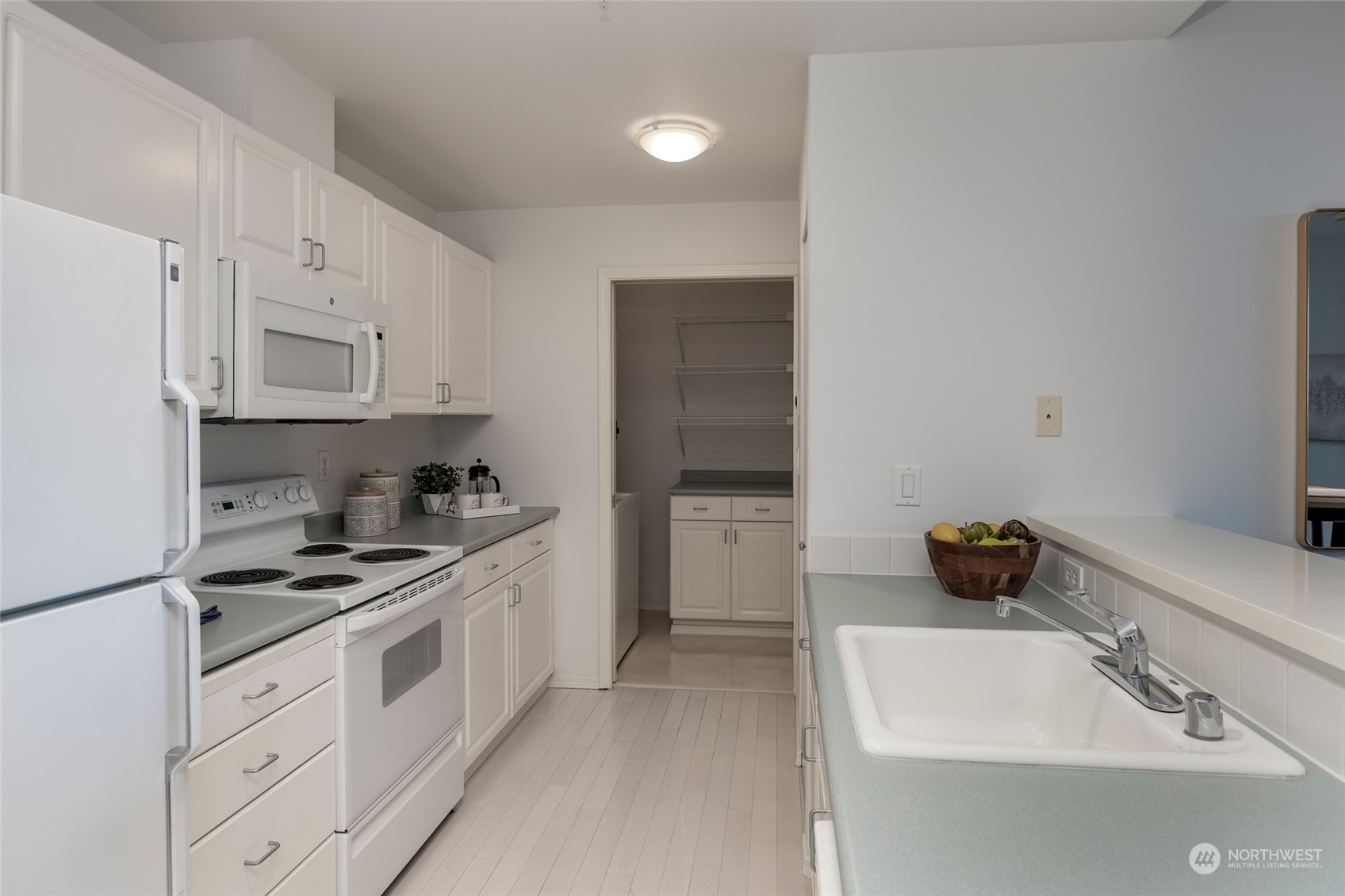 3221 Southwest Avalon Way, Unit 305 Seattle, WA 98126 - Photo 7 of 40 a kitchen with white cabinets and appliances