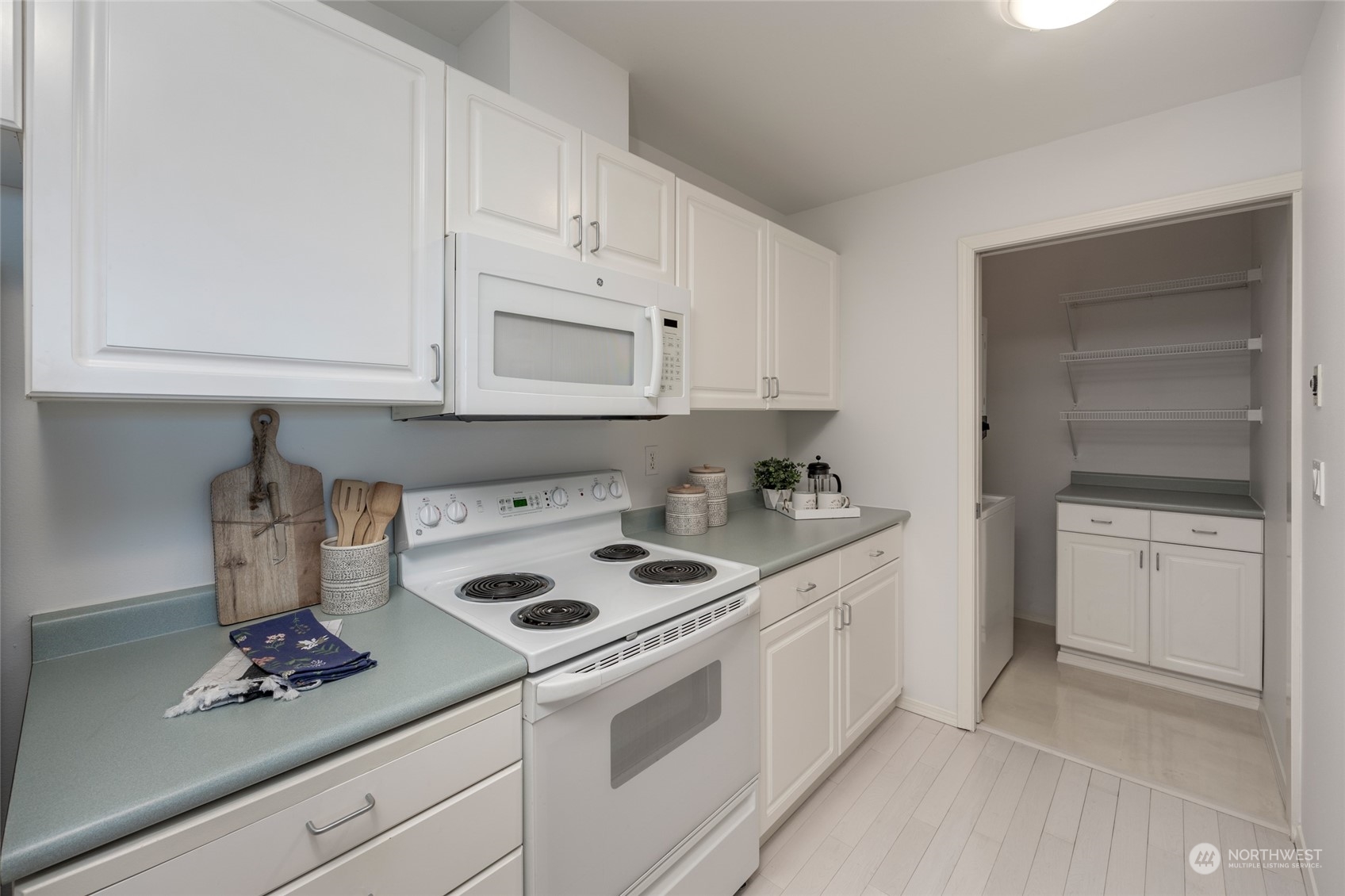 3221 Southwest Avalon Way, Unit 305 Seattle, WA 98126 - Photo 9 of 40 a kitchen with white cabinets and white appliances