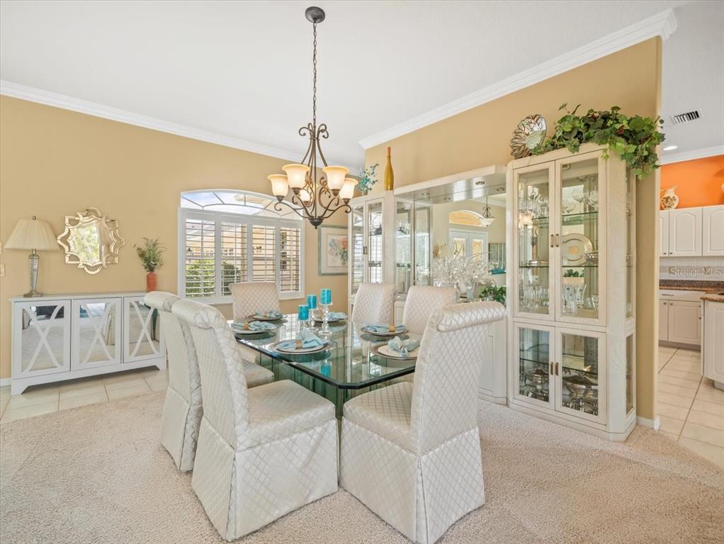 9216 Tarleton Circle Weeki Wachee, FL 34613 - Photo 12 of 66 a dining room with furniture a chandelier and window