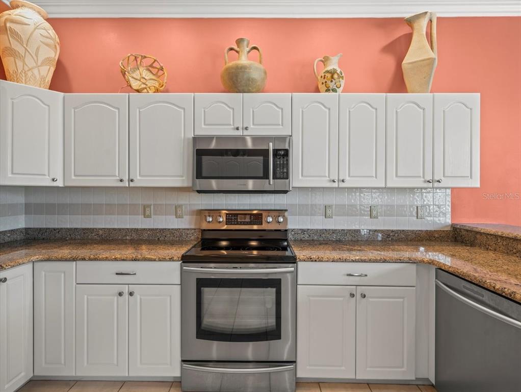 9216 Tarleton Circle Weeki Wachee, FL 34613 - Photo 32 of 66 a kitchen with stainless steel appliances granite countertop white cabinets and a stove