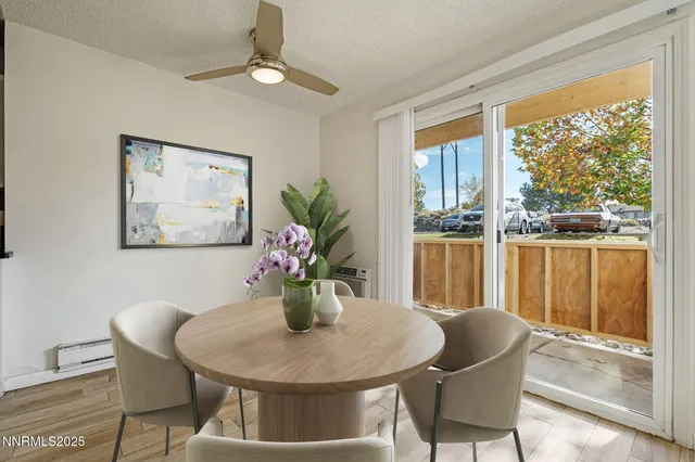 a dining room with furniture a large window and wooden floor