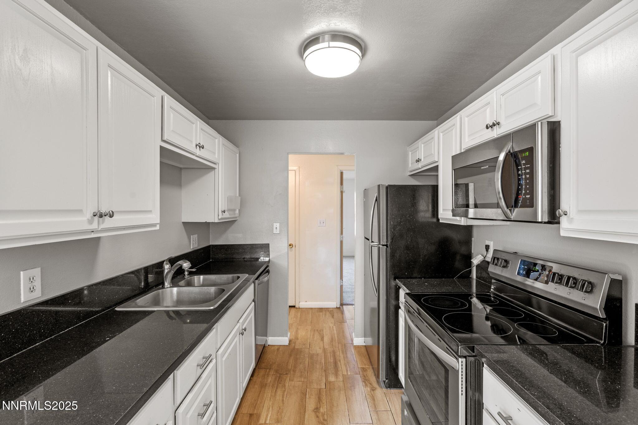 3915 Clear Acre Lane, Unit 149 Reno, NV 89512 - Photo 5 of 16 a kitchen with a sink stove and microwave