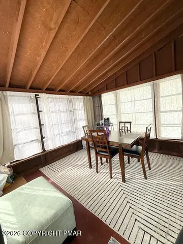 a dining room with furniture and a large window