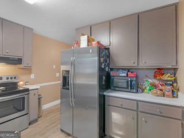 a kitchen with stainless steel appliances granite countertop a refrigerator and a stove top oven