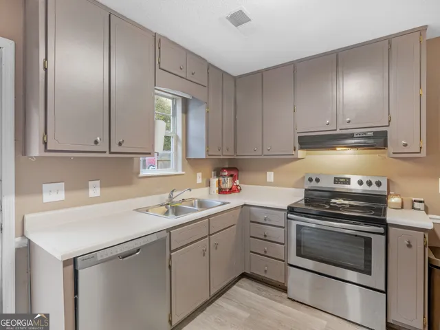 a kitchen with cabinets appliances and a sink