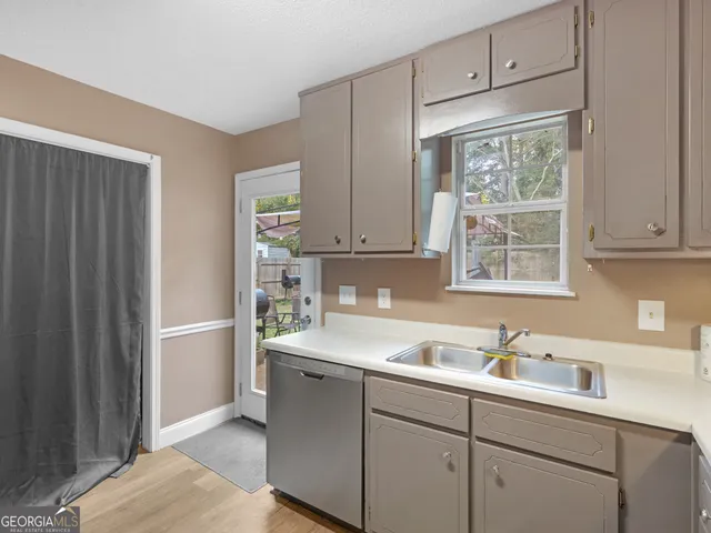 a kitchen with a sink cabinets appliances and a window