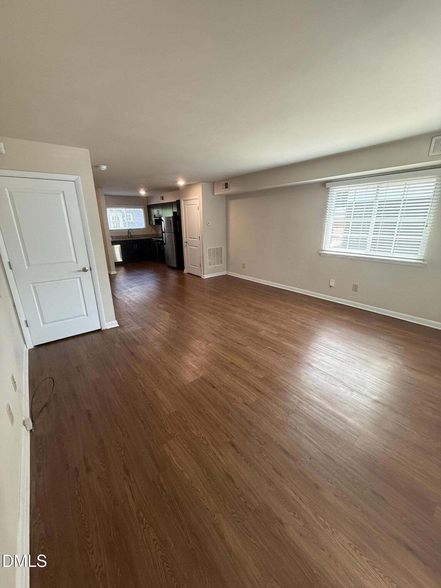 2616 Noble Road, Unit D Raleigh, NC 27608 - Photo 2 of 9 a view of empty room with wooden floor