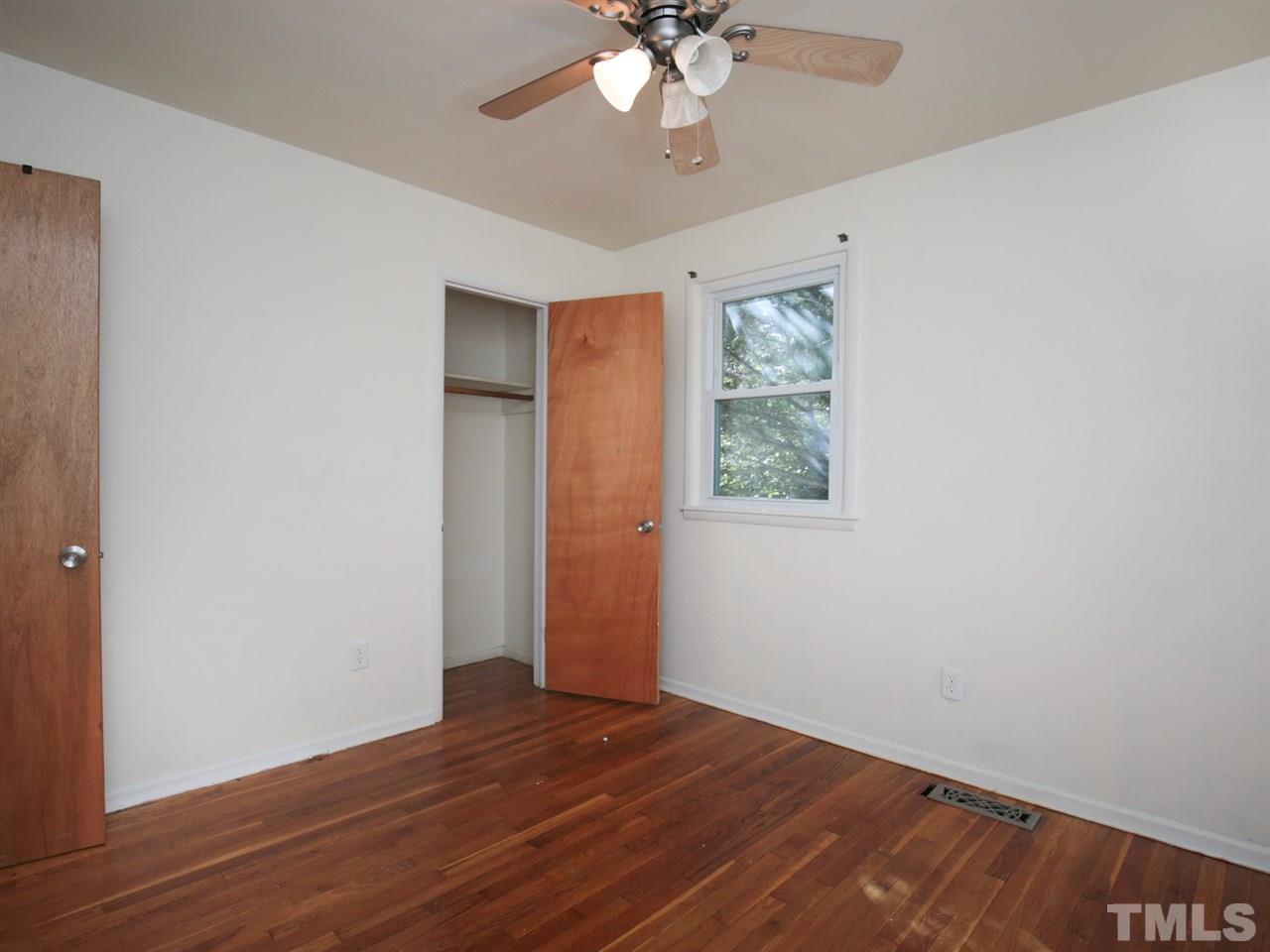 3421 Cheyenne Road Raleigh, NC 27609 - Photo 8 of 25 a view of an empty room with wooden floor and a ceiling fan