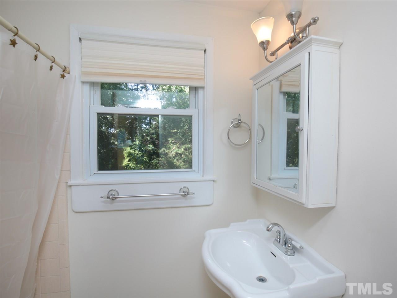 3421 Cheyenne Road Raleigh, NC 27609 - Photo 9 of 25 a bathroom with a sink a mirror and a bathtub