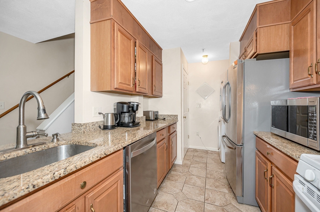 39 Broadway, Unit 305 Malden, MA 02148 - Photo 6 of 36 a kitchen with stainless steel appliances granite countertop a sink stove and refrigerator