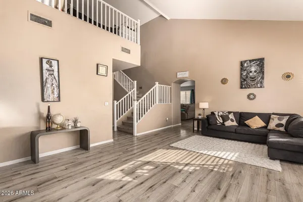 a living room with furniture and a wooden floor
