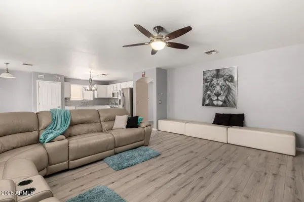 a living room with furniture and a ceiling fan
