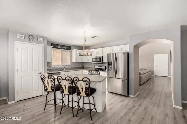 a kitchen with stainless steel appliances a refrigerator a stove a sink dishwasher with a dining table and chairs