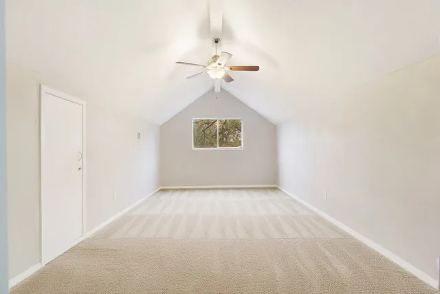 an empty room with a window and a ceiling fan