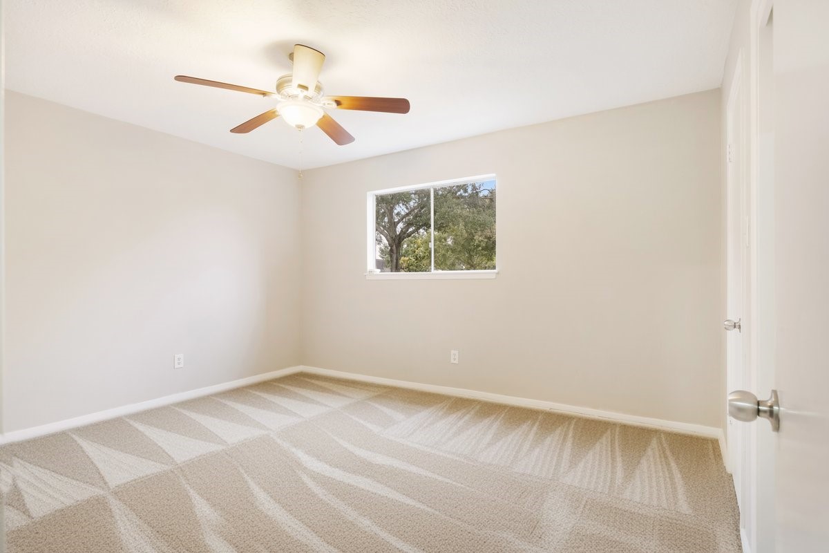 1403 Neptune Lane Houston, TX 77062 - Photo 14 of 20 an empty room with a window and a ceiling fan