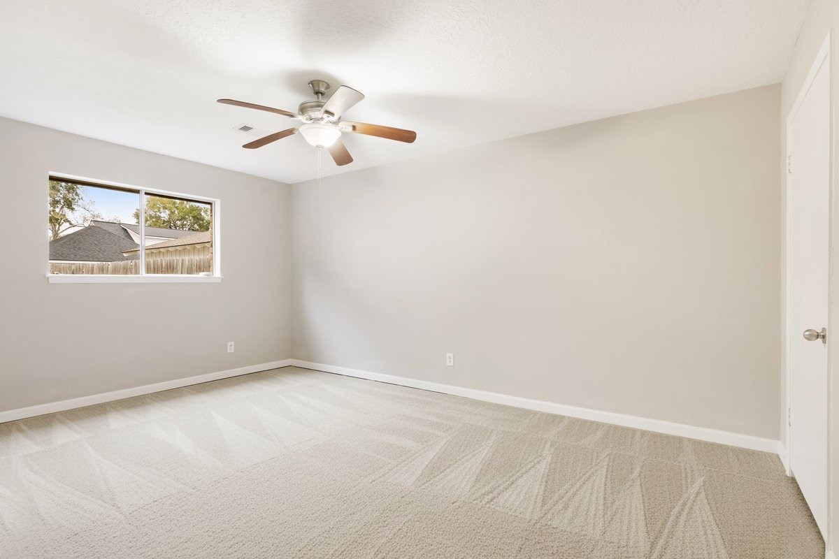 1403 Neptune Lane Houston, TX 77062 - Photo 17 of 20 an empty room with windows and fan