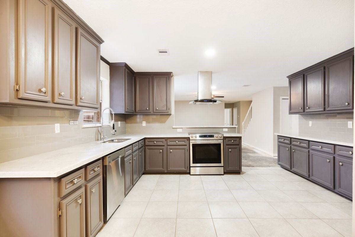 1403 Neptune Lane Houston, TX 77062 - Photo 5 of 20 a kitchen with stainless steel appliances granite countertop a sink and stove top oven