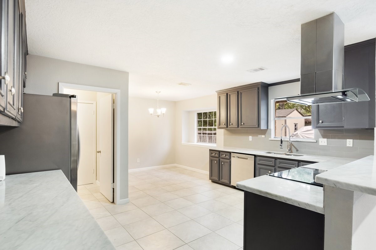 1403 Neptune Lane Houston, TX 77062 - Photo 6 of 20 a kitchen with stainless steel appliances a sink stove and refrigerator