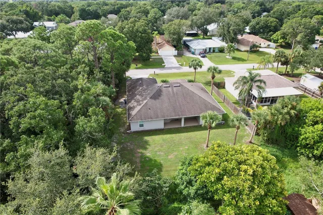 an aerial view of residential houses with outdoor space and trees