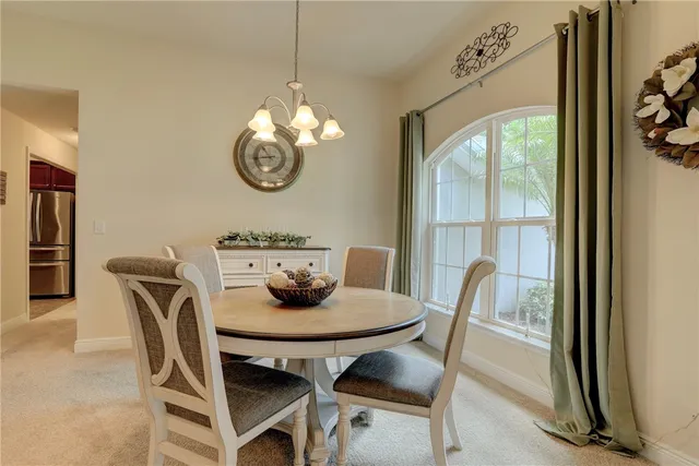 a dining room with furniture a rug and a mirror