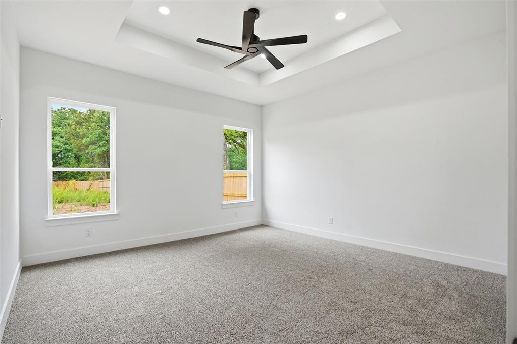1111 Riverwood Road Dallas, TX 75217 - Photo 34 of 40 Spacious room featuring a tray ceiling with recessed lighting and a contemporary ceiling fan