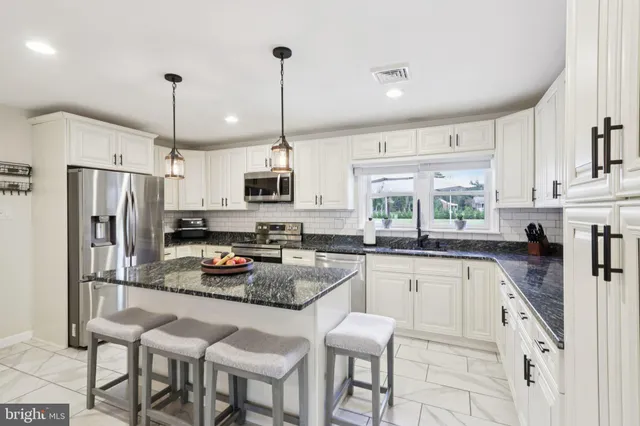 a kitchen with white cabinets and refrigerator