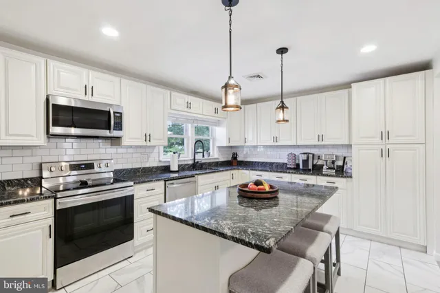 a kitchen with a stove a sink and a microwave