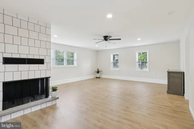 an empty room with windows and fireplace