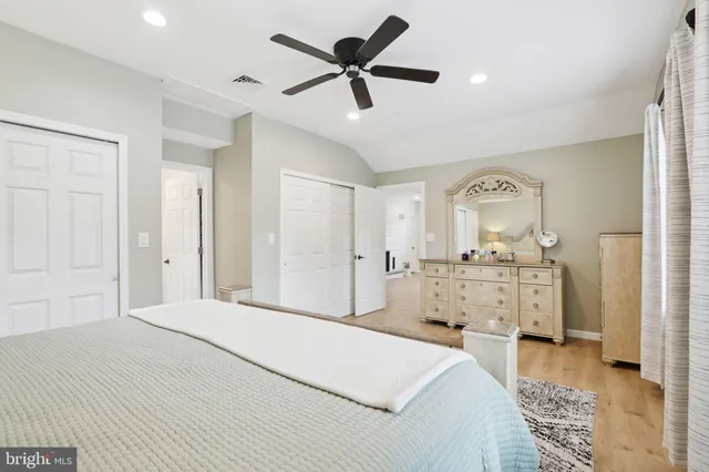 a bedroom with a bed and a chandelier fan