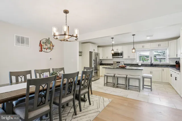 a kitchen with kitchen island a dining table and chairs